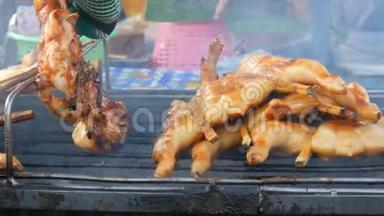 全鸡胴体烤架串在木棒上烤在烤架上。 泰国街头美食。 男人`双手翻身